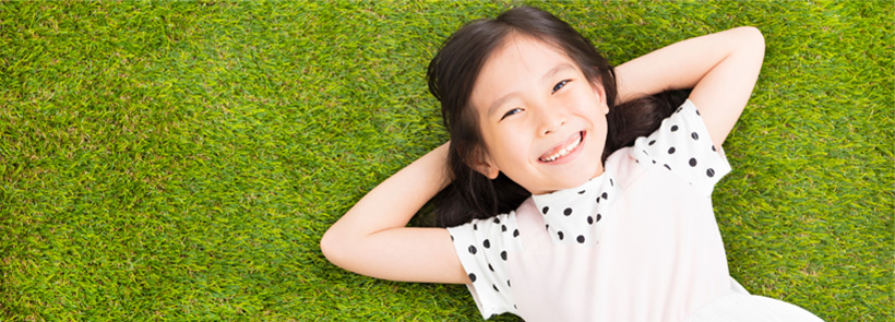 Girl relaxing on a grass lawn